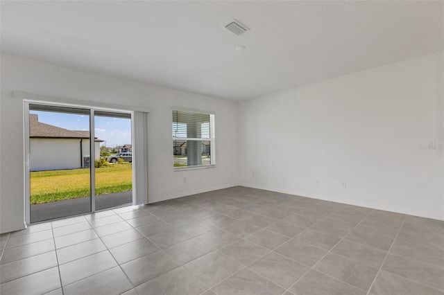 unfurnished room with tile patterned flooring, visible vents, and baseboards