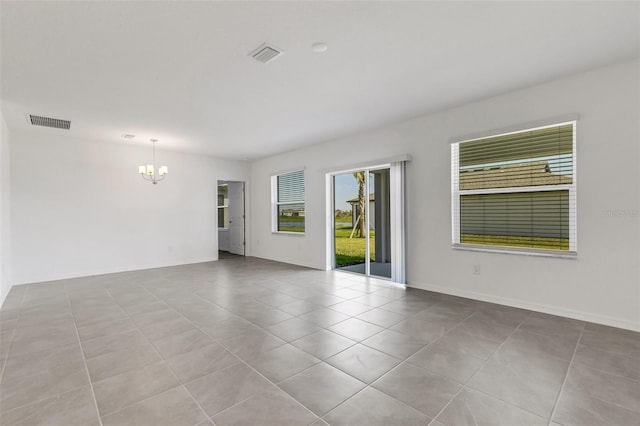 spare room featuring baseboards, tile patterned flooring, visible vents, and an inviting chandelier