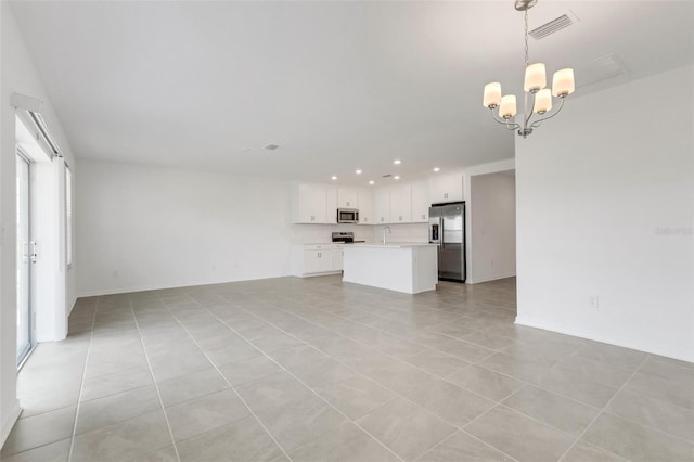 unfurnished living room with light tile patterned floors, visible vents, a notable chandelier, a sink, and recessed lighting