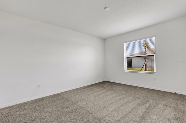 carpeted empty room with baseboards