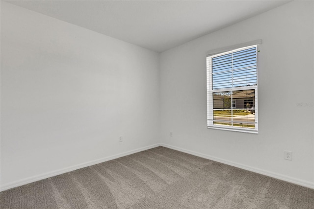 unfurnished room with carpet flooring and baseboards