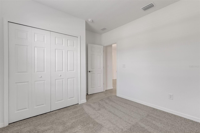 unfurnished bedroom with baseboards, a closet, visible vents, and carpet flooring