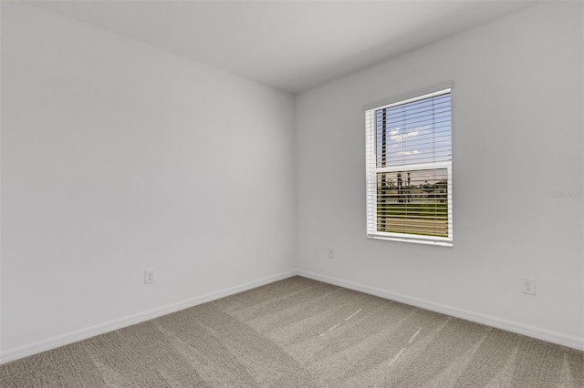 unfurnished room featuring carpet flooring and baseboards