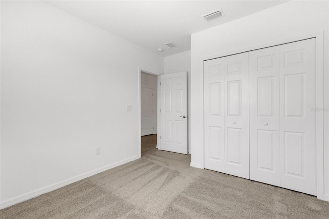 unfurnished bedroom featuring a closet, carpet flooring, visible vents, and baseboards