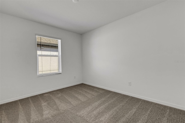 carpeted spare room with baseboards