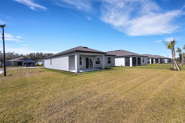 rear view of property with a lawn and stucco siding