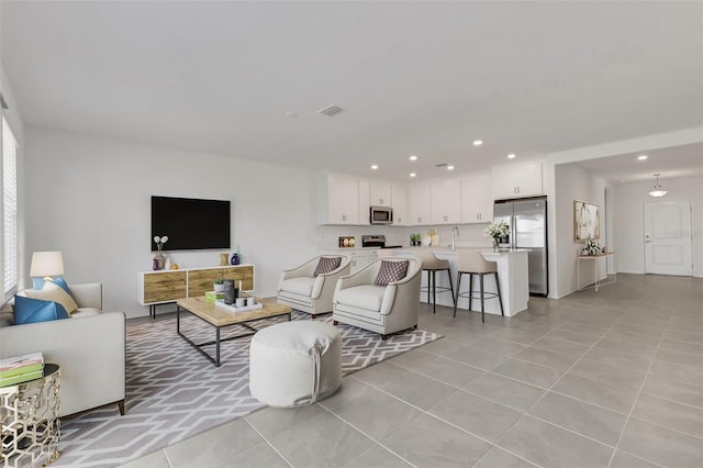 living area with recessed lighting and light tile patterned flooring