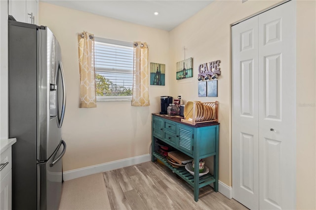 interior space featuring light wood-type flooring and baseboards