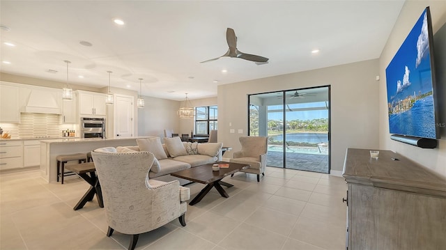 living area with light tile patterned floors, baseboards, a ceiling fan, and recessed lighting