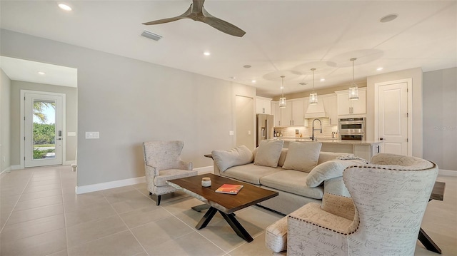 living area featuring baseboards, visible vents, a ceiling fan, and light tile patterned flooring