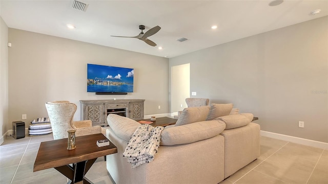 living area with light tile patterned floors, baseboards, visible vents, and a ceiling fan