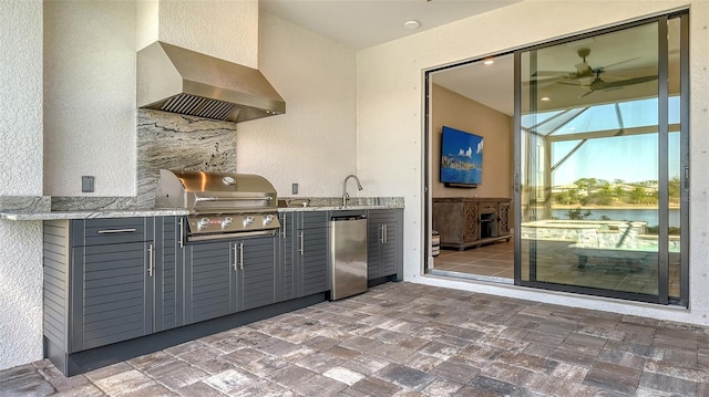 interior space with wall chimney exhaust hood, ceiling fan, refrigerator, light stone countertops, and gray cabinetry