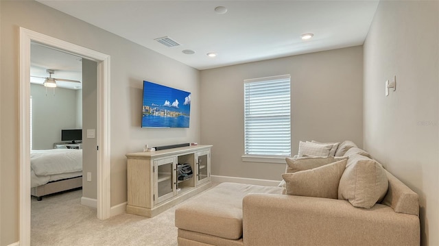 living area with light carpet, visible vents, and baseboards