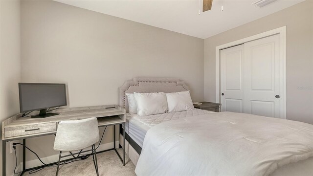 carpeted bedroom with a ceiling fan, a closet, visible vents, and baseboards