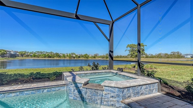 view of swimming pool featuring glass enclosure, a water view, a lawn, and an in ground hot tub