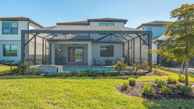 back of property with a patio area, a pool with connected hot tub, glass enclosure, and a lawn