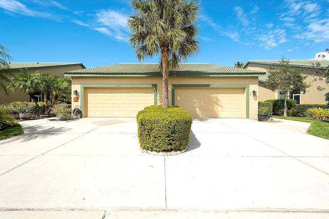 view of front of house featuring driveway, an attached garage, and stucco siding