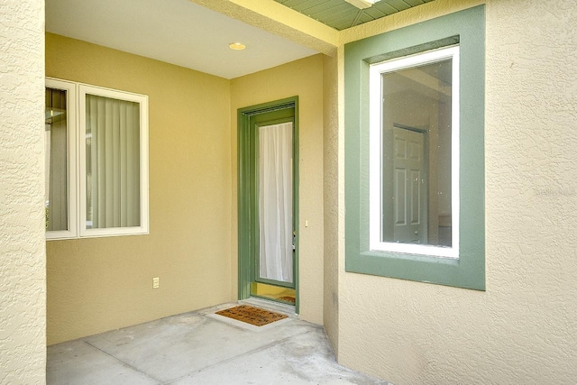 view of exterior entry featuring stucco siding