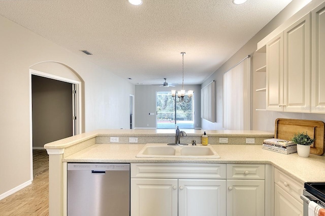 kitchen featuring white cabinets, appliances with stainless steel finishes, a peninsula, light countertops, and a sink