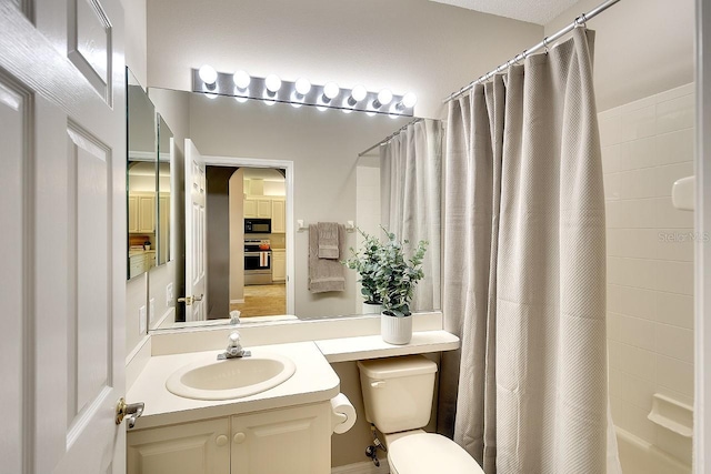 bathroom featuring toilet, shower / bath combo with shower curtain, and vanity