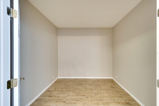 spare room with light wood-type flooring and baseboards