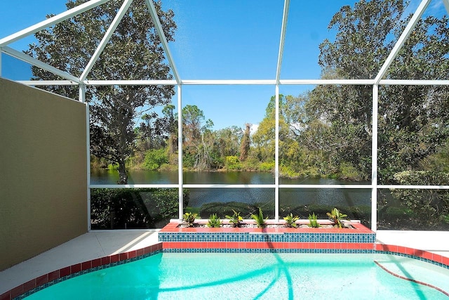 outdoor pool with a water view, glass enclosure, and a patio