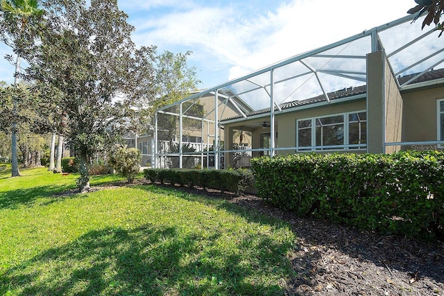 view of yard with a lanai and ceiling fan