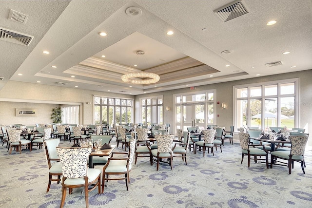 carpeted dining room featuring a tray ceiling and visible vents