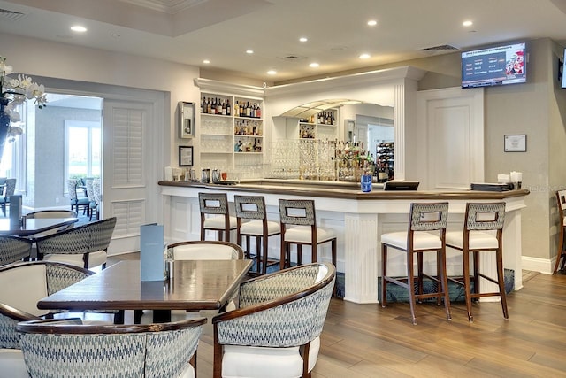 bar featuring indoor wet bar, wood finished floors, visible vents, and recessed lighting