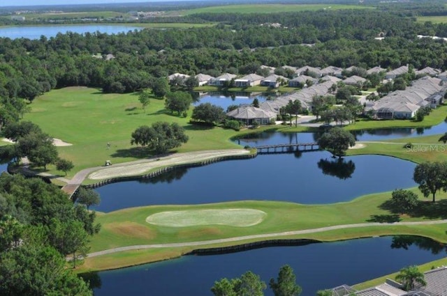 aerial view featuring a forest view, a water view, and golf course view