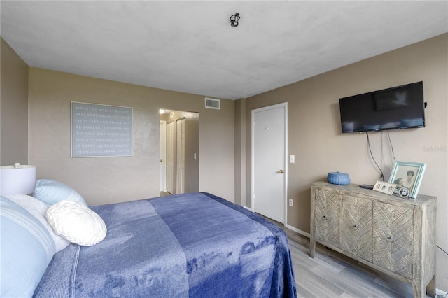 bedroom featuring visible vents and wood finished floors