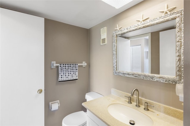 bathroom featuring visible vents, toilet, and vanity