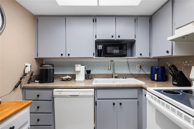 kitchen featuring gray cabinets, a sink, tasteful backsplash, white appliances, and light countertops