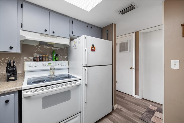 kitchen featuring white appliances, light countertops, visible vents, and under cabinet range hood