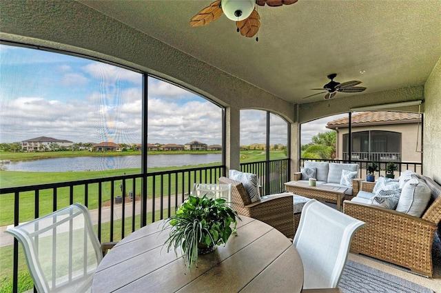 sunroom with a water view, a healthy amount of sunlight, and ceiling fan