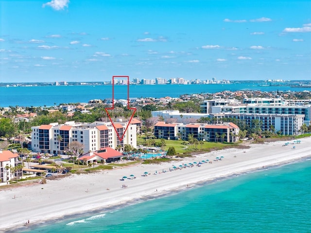 aerial view featuring a view of the beach, a water view, and a view of city