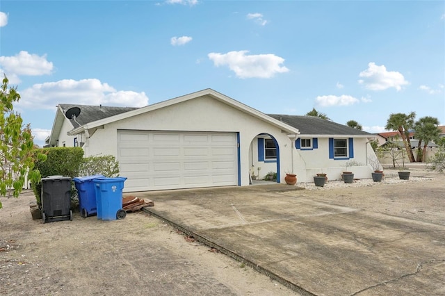 ranch-style house featuring a garage, concrete driveway, and stucco siding