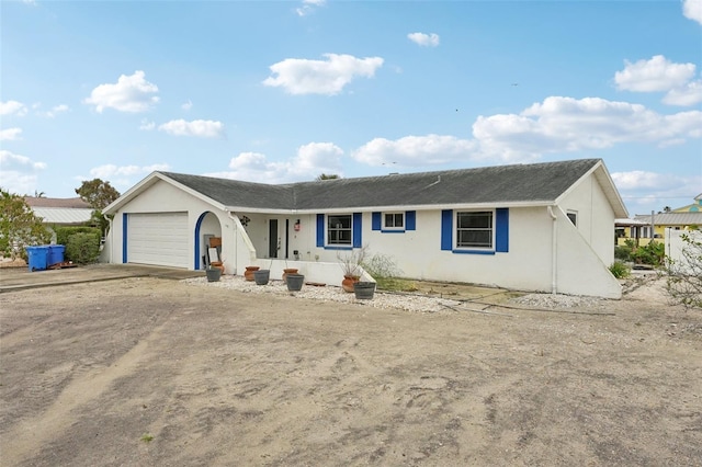 ranch-style home featuring a garage, driveway, and stucco siding