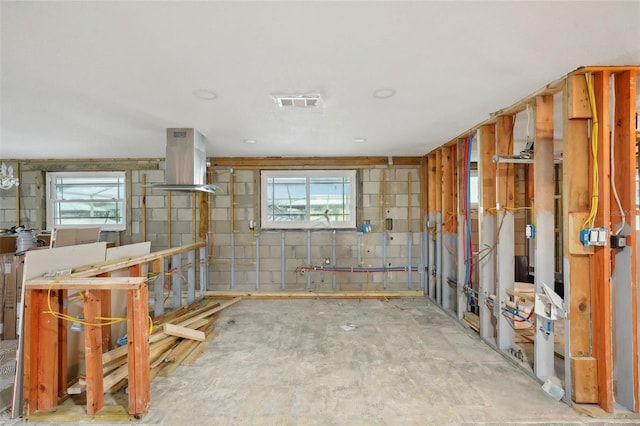 interior space with concrete block wall and visible vents