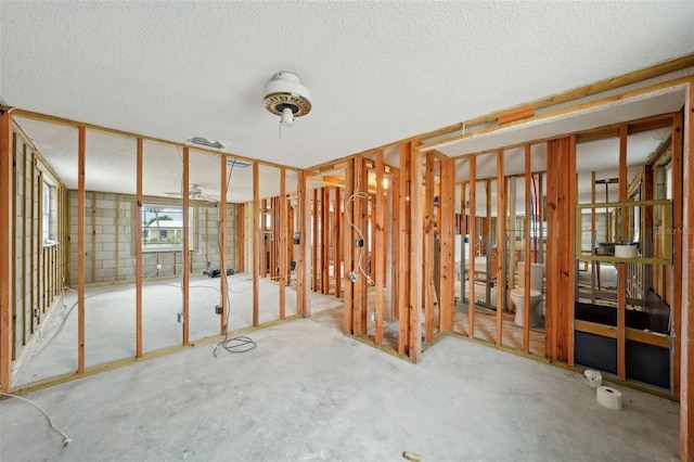 misc room with concrete block wall and a textured ceiling