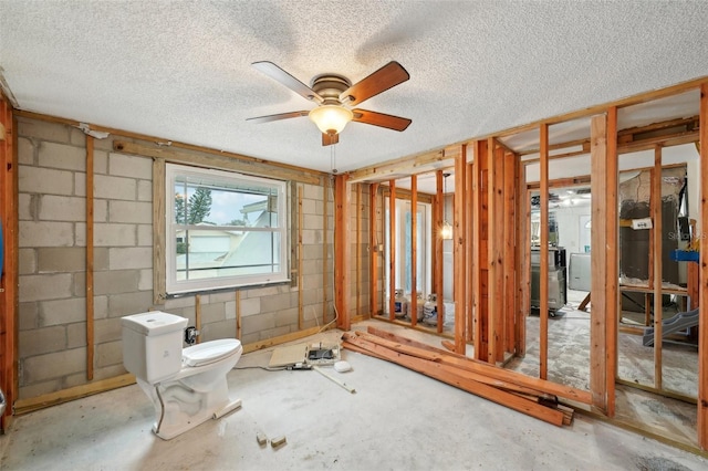 bathroom featuring concrete block wall, concrete floors, and a textured ceiling