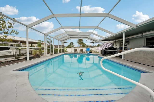 outdoor pool with a patio area and glass enclosure