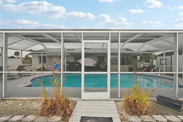 outdoor pool featuring glass enclosure and a patio area