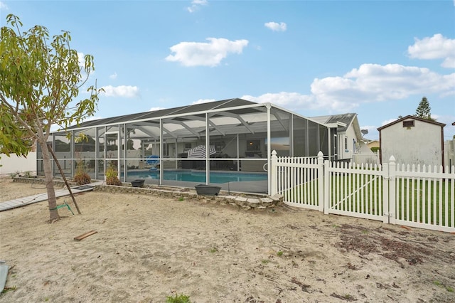 exterior space featuring glass enclosure, fence, and a fenced in pool