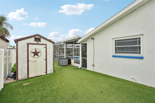 view of yard with an outbuilding, a storage unit, fence, and a sunroom