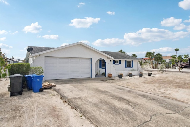 ranch-style home featuring an attached garage, concrete driveway, and stucco siding