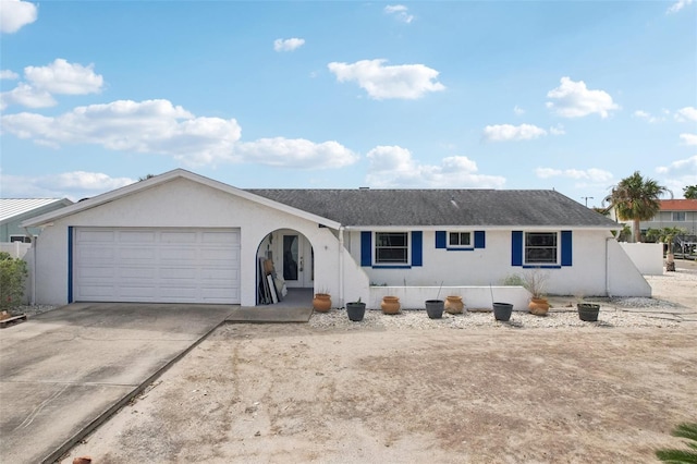 ranch-style home featuring driveway, an attached garage, and stucco siding