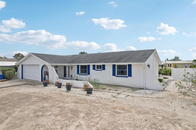 single story home featuring concrete driveway, an attached garage, fence, and stucco siding