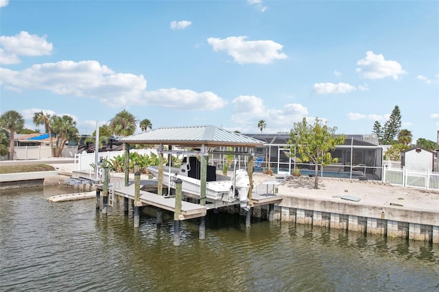 dock area with a water view, glass enclosure, boat lift, and fence