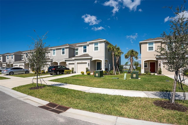 view of front of house featuring a residential view, stucco siding, driveway, and a front yard